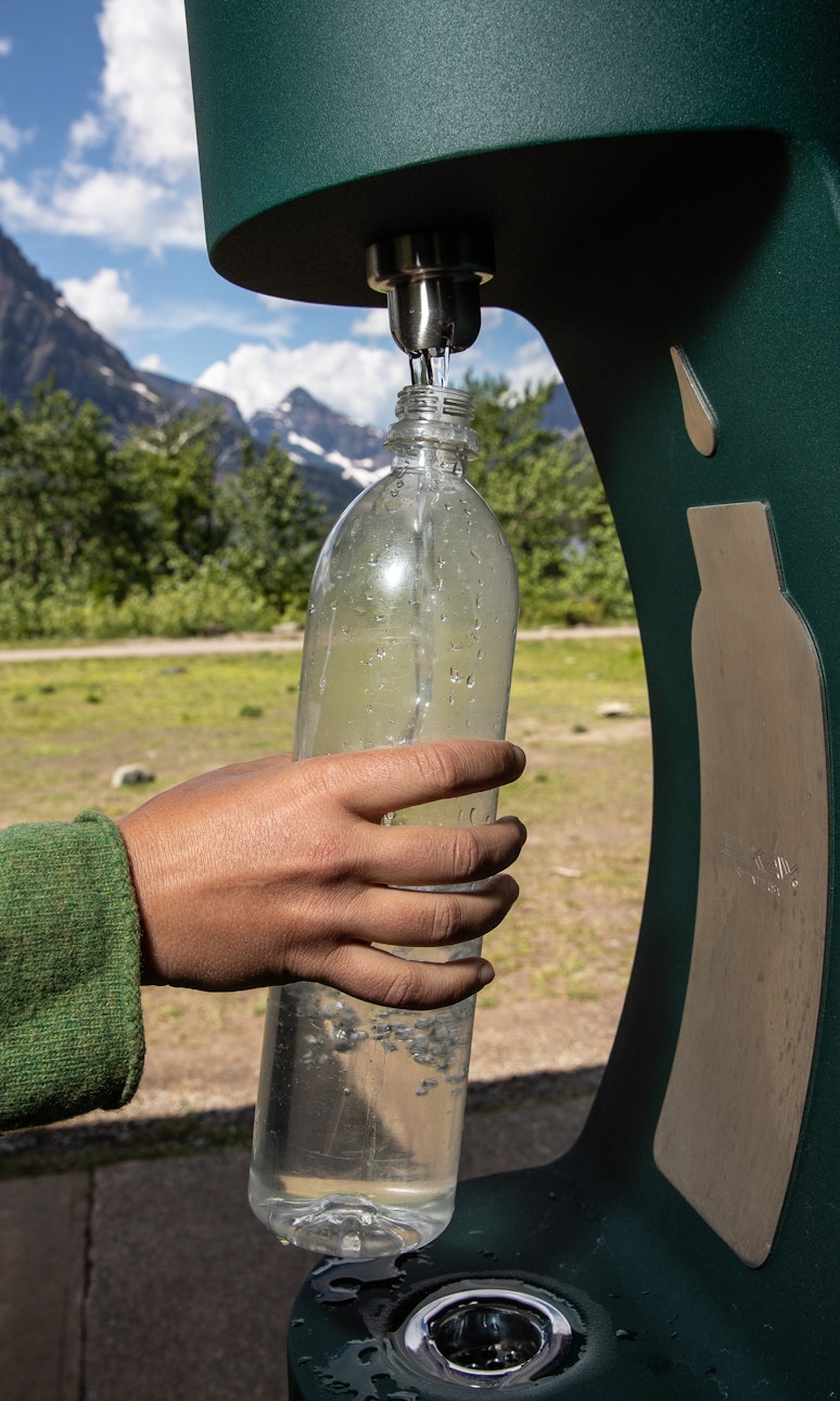 一个人在一个水瓶补充站给一个水瓶补充水