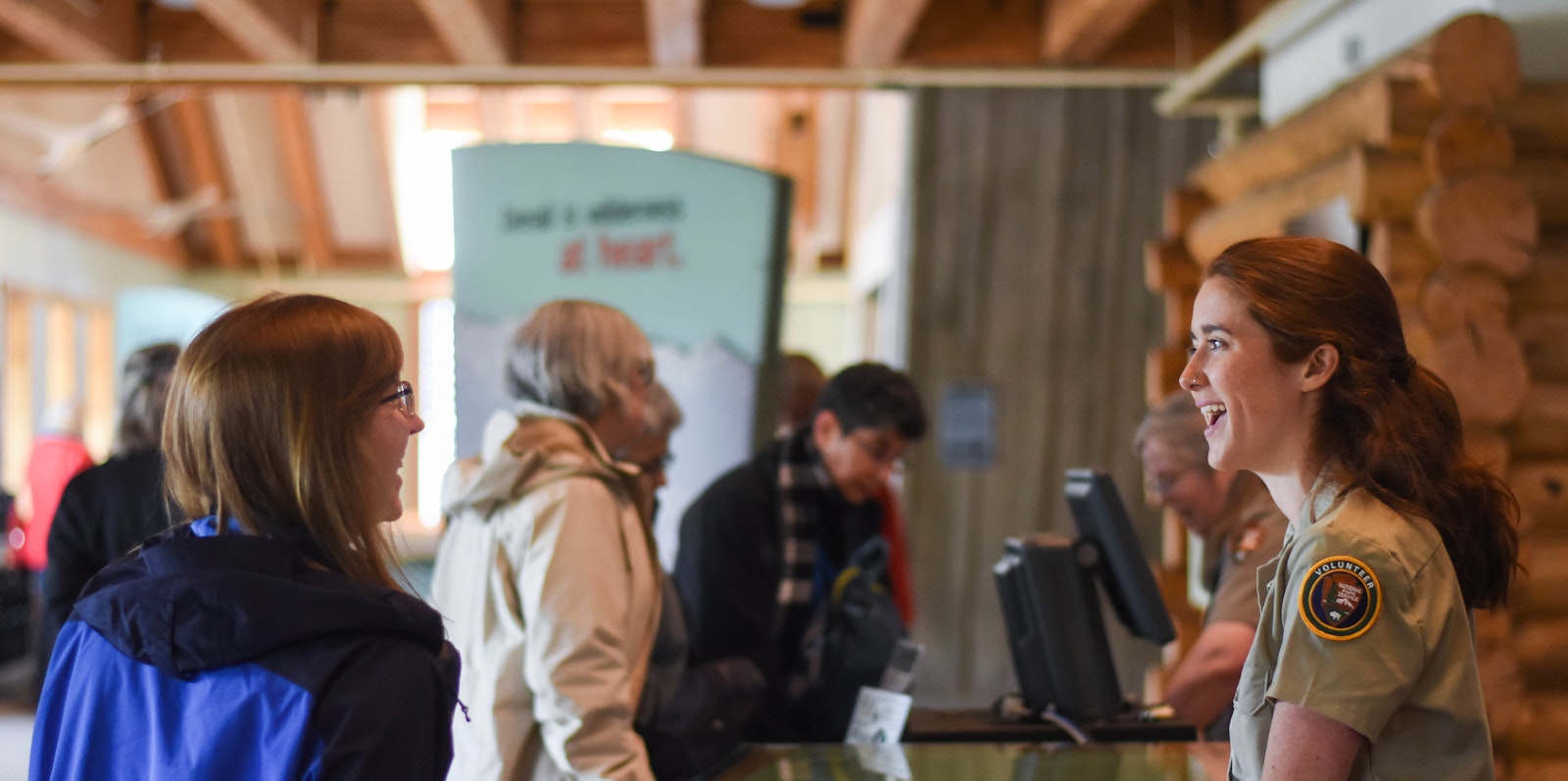 a volunteer in a visitor center greets guests