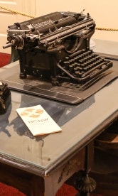 Phone and typewriter sit on a desk