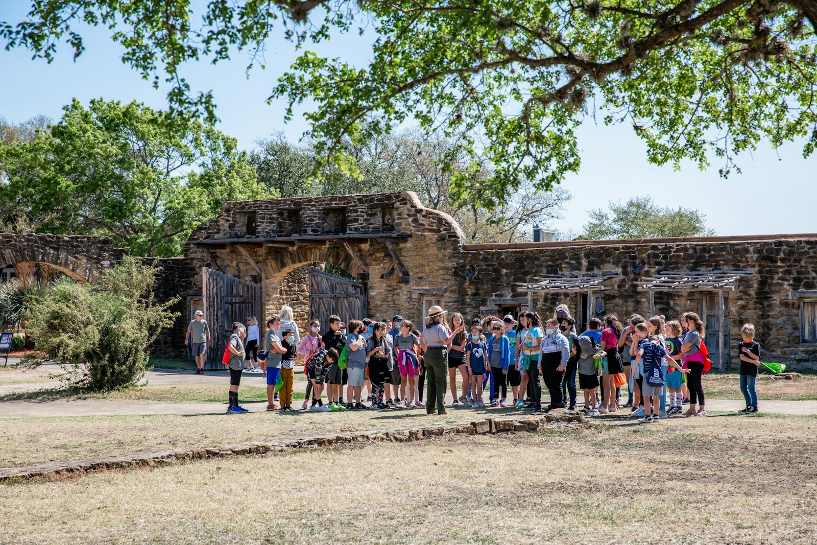 A group of students gather outside a historic stone structure