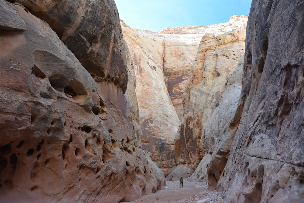 Person walking through the base of a tall canyon