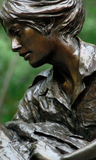 Close up of a statue depicting a woman holding a wounded soldier