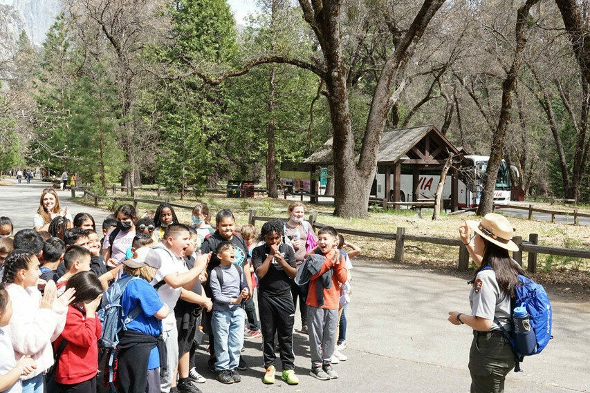 A park ranger stands before a group of students