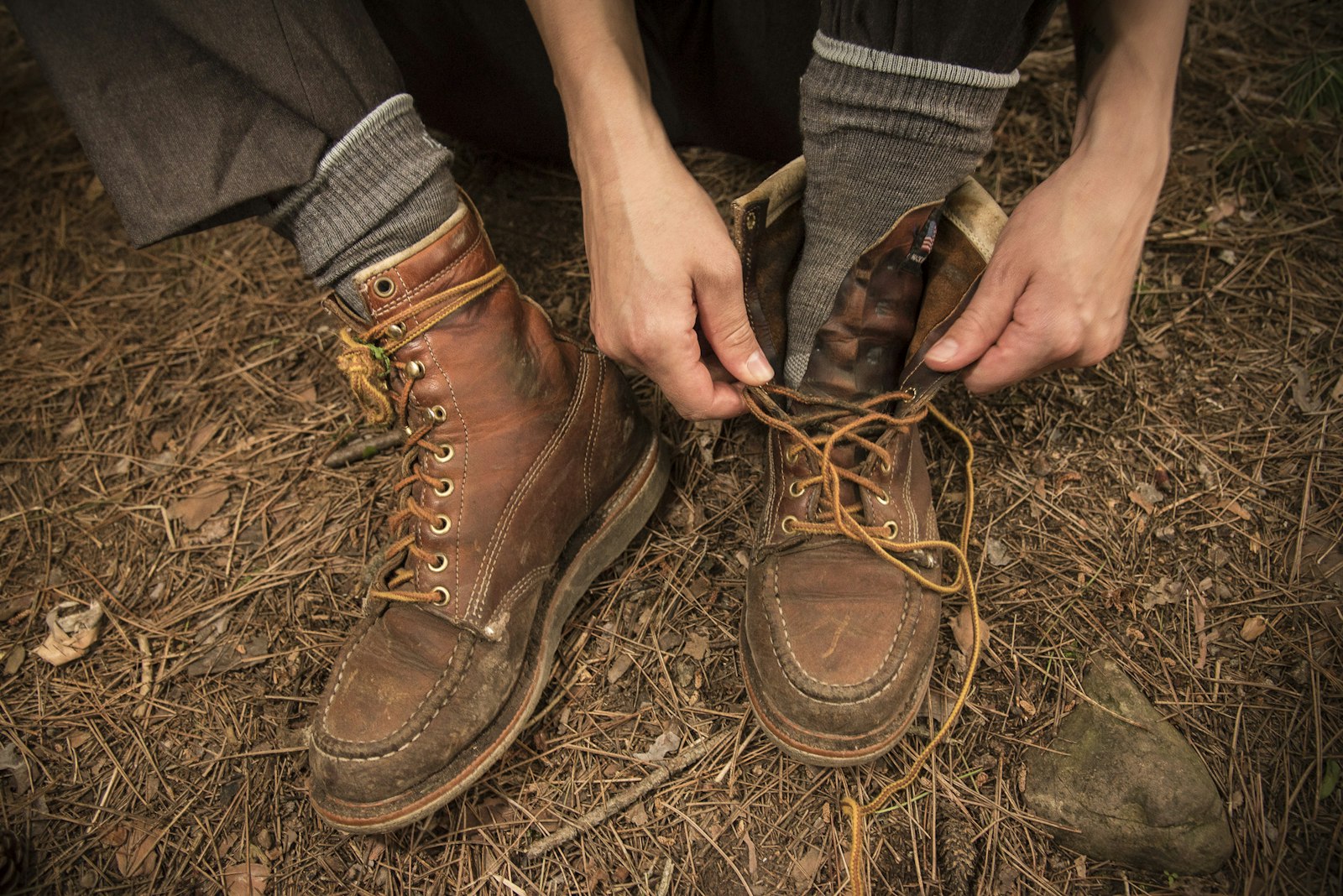 A person reaches down to tike their hiking boots.