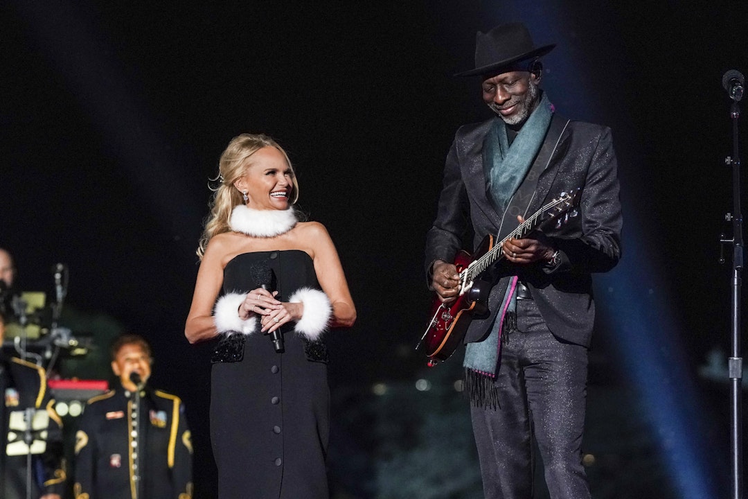 Kristin Chenoweth smiles and glances at Keb' Mo' who is playing guitar and smiling