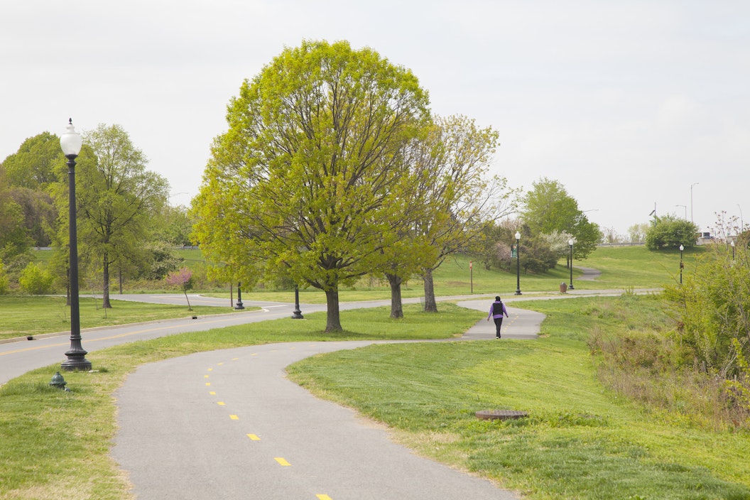 A person walks along a paved bike trail
