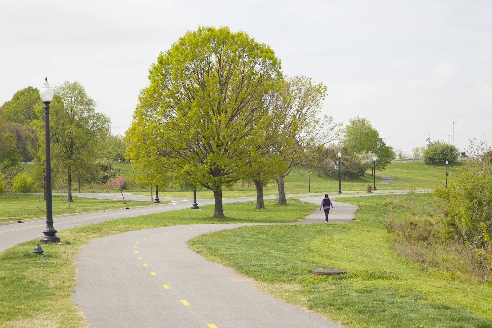 A person walks along a paved bike trail