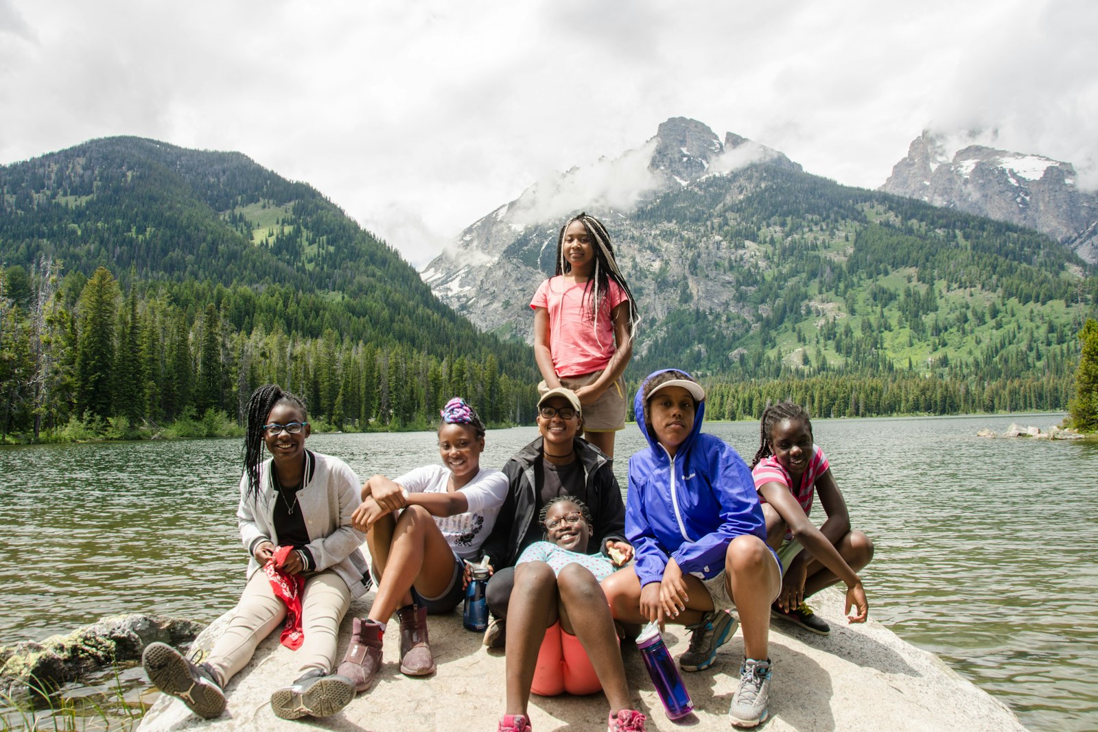 Desahray Johnson with City Kids participants sitting in front of a lake in Grand Teton National Park, 2017