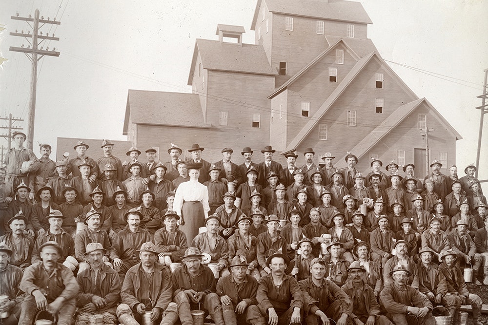 Historic photograph of a crowd of people in front of a mine shaft