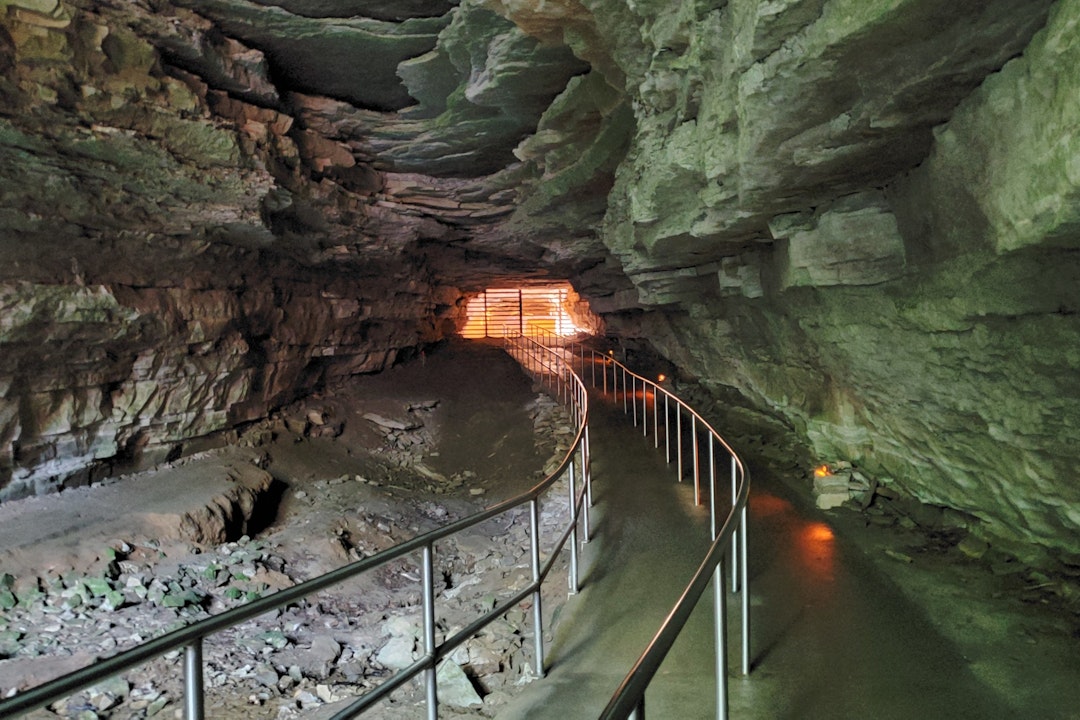 A trail lined with handrails leads deeper into the cave