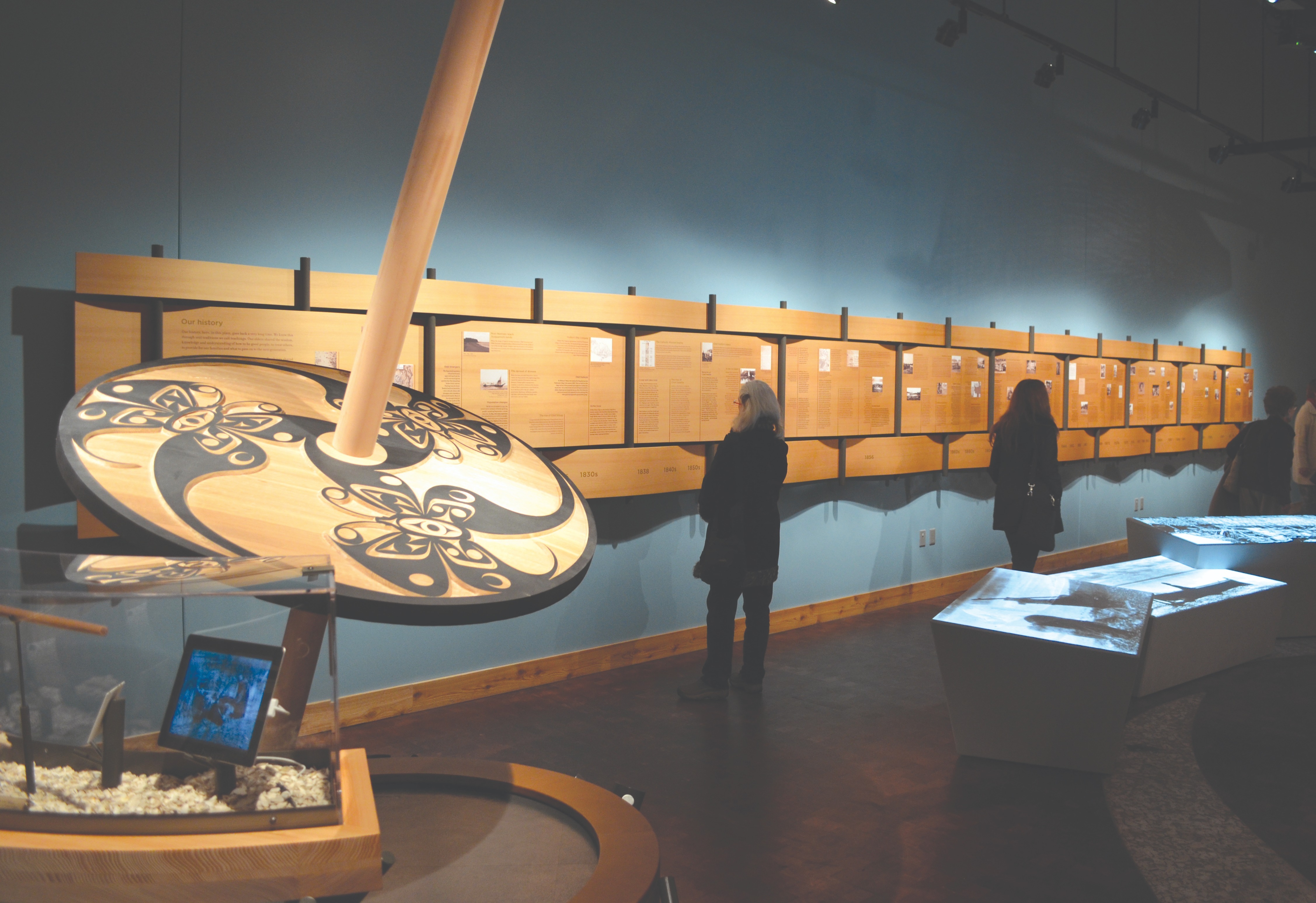 Two people stand and look at exhibits in a museum