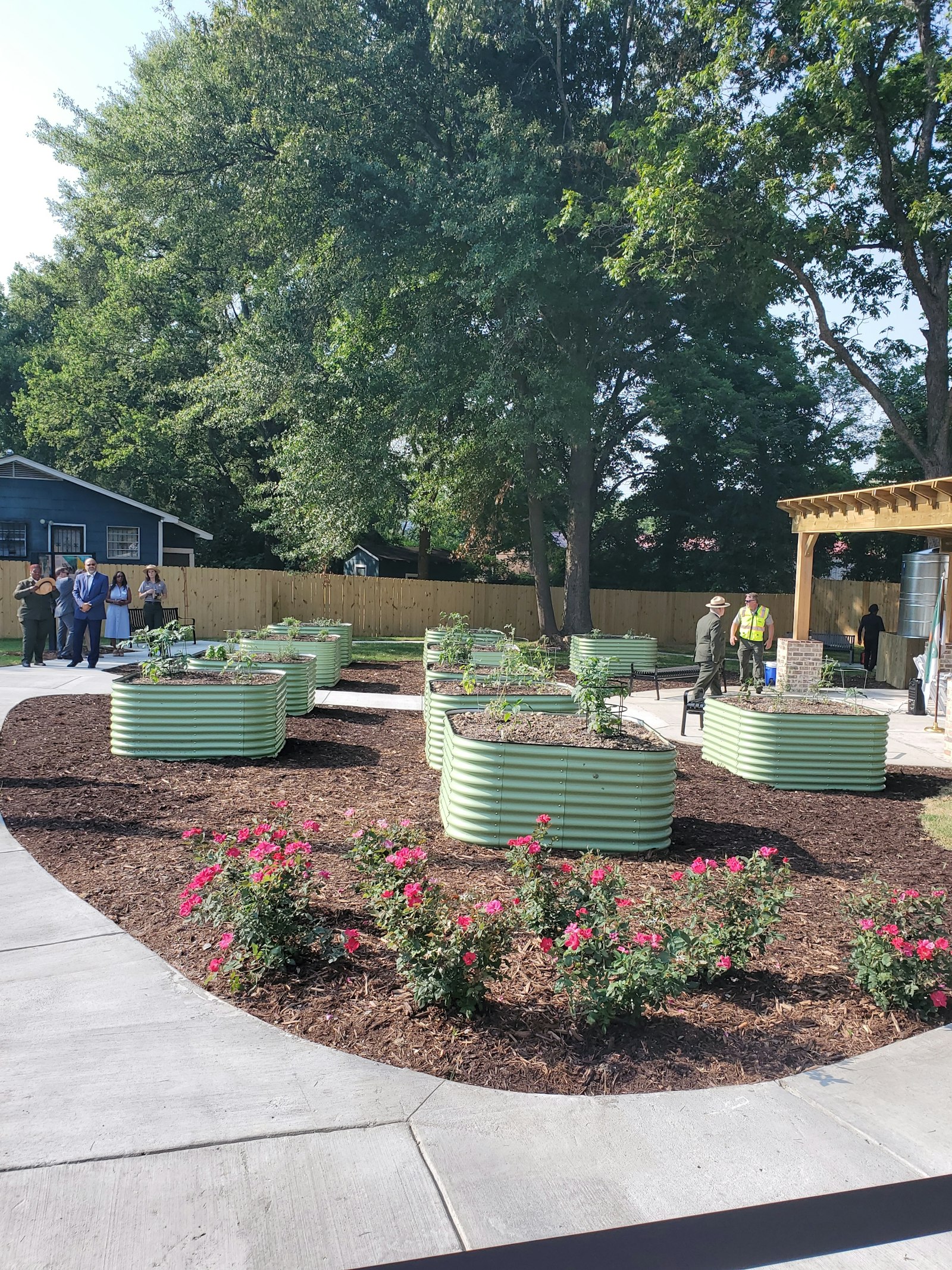 Raised garden beds in a community garden, with a paved path winding around