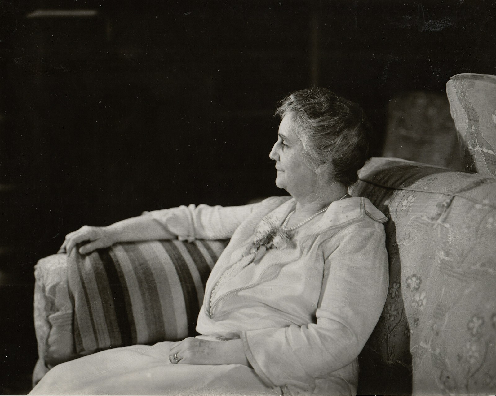 A profile photo of a woman seated on a couch.