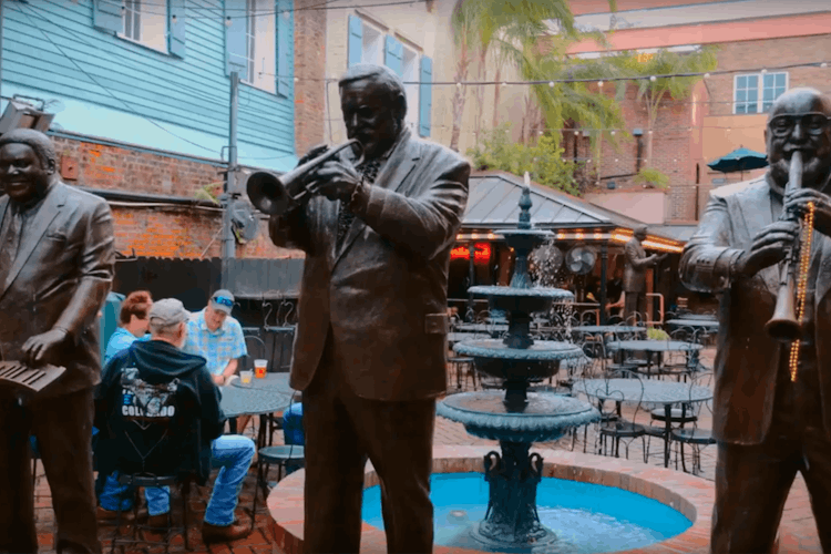Statues of jazz musicians stand in an open courtyard