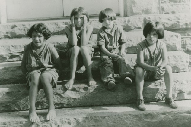 Historic photograph of children sitting on stone steps