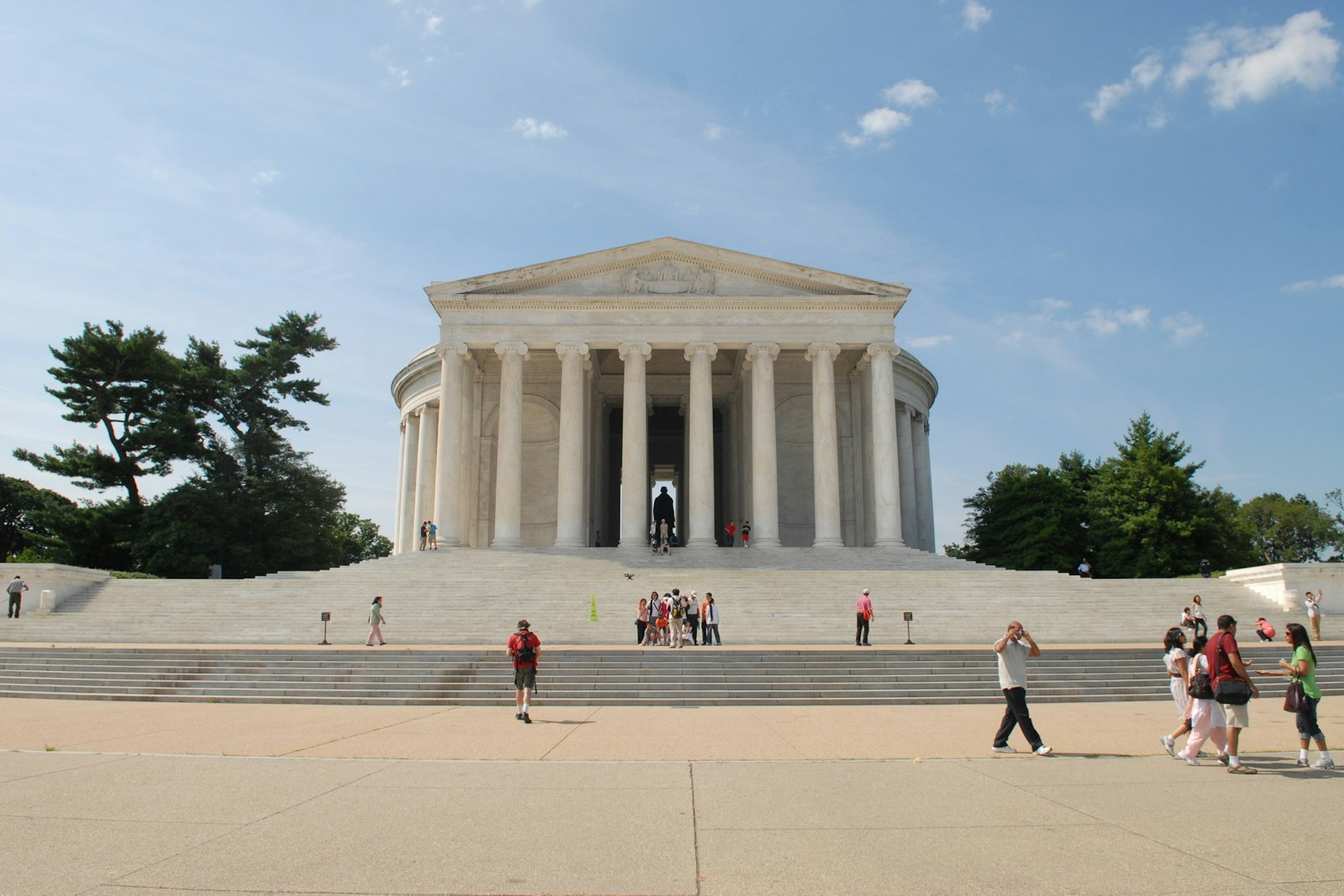 People walking up and down the steps of the Jefferson Memorial, a large domed stone structure