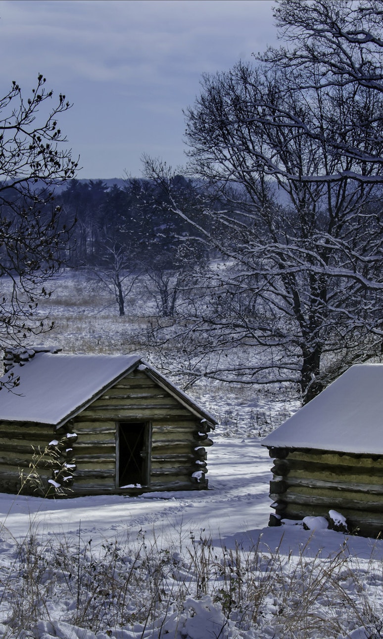 Reconstructed log cabins covered in a thin film of snow