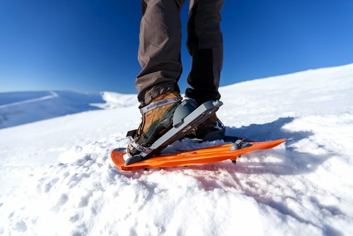 Close up photo of a person wearing snowshoes
