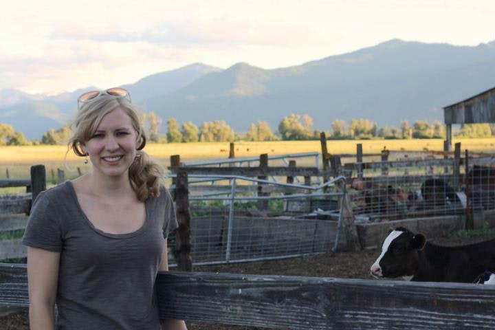 Nicole Martin poses on a farm with mountains in the background