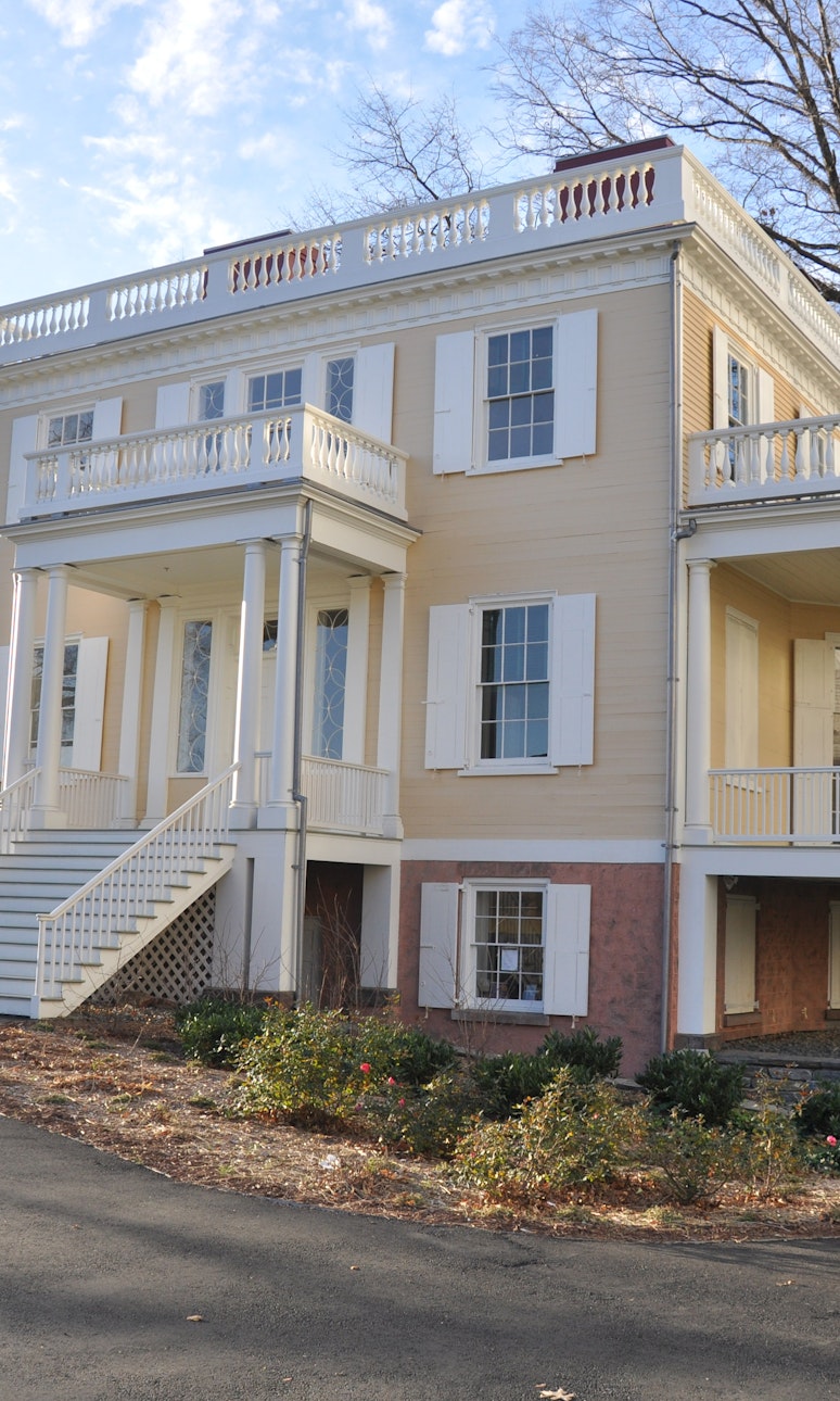 Exterior of 2 story home with covered porches and steps up to the front door