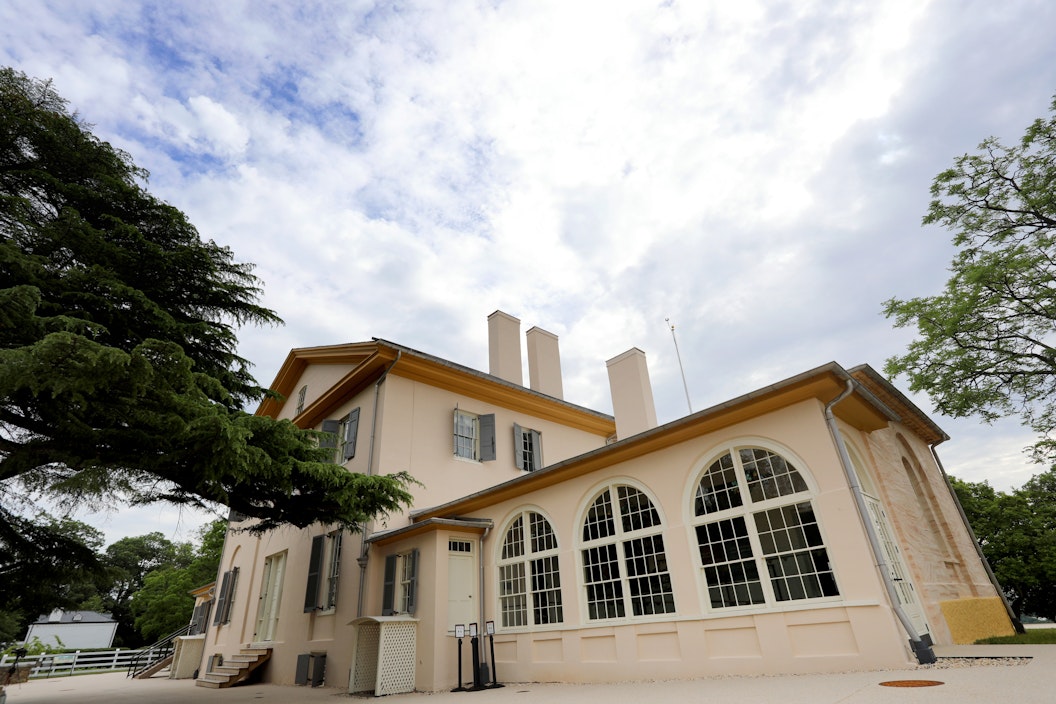 Two-story cream-colored home with red-brown roof