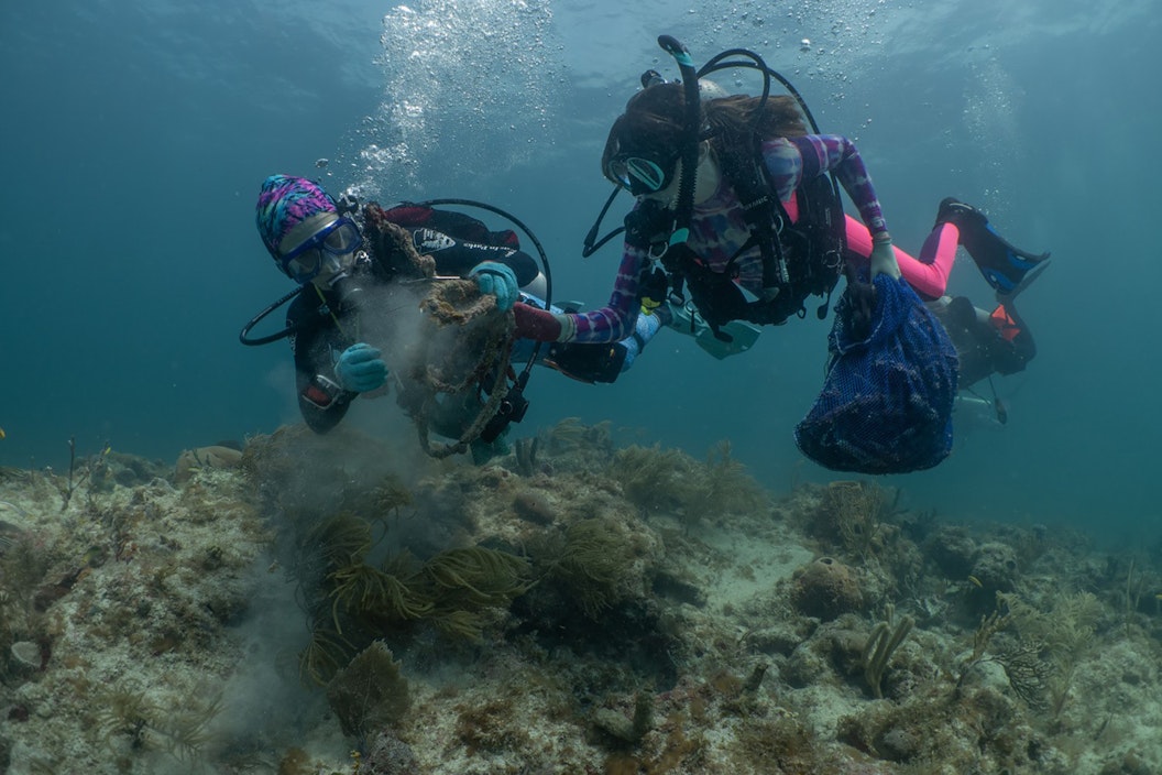 Two women scuba dive, as seen underwater