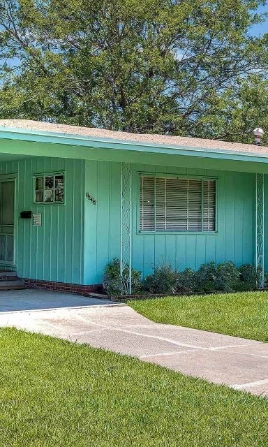 Bright teal ranch-style home with a covered porch