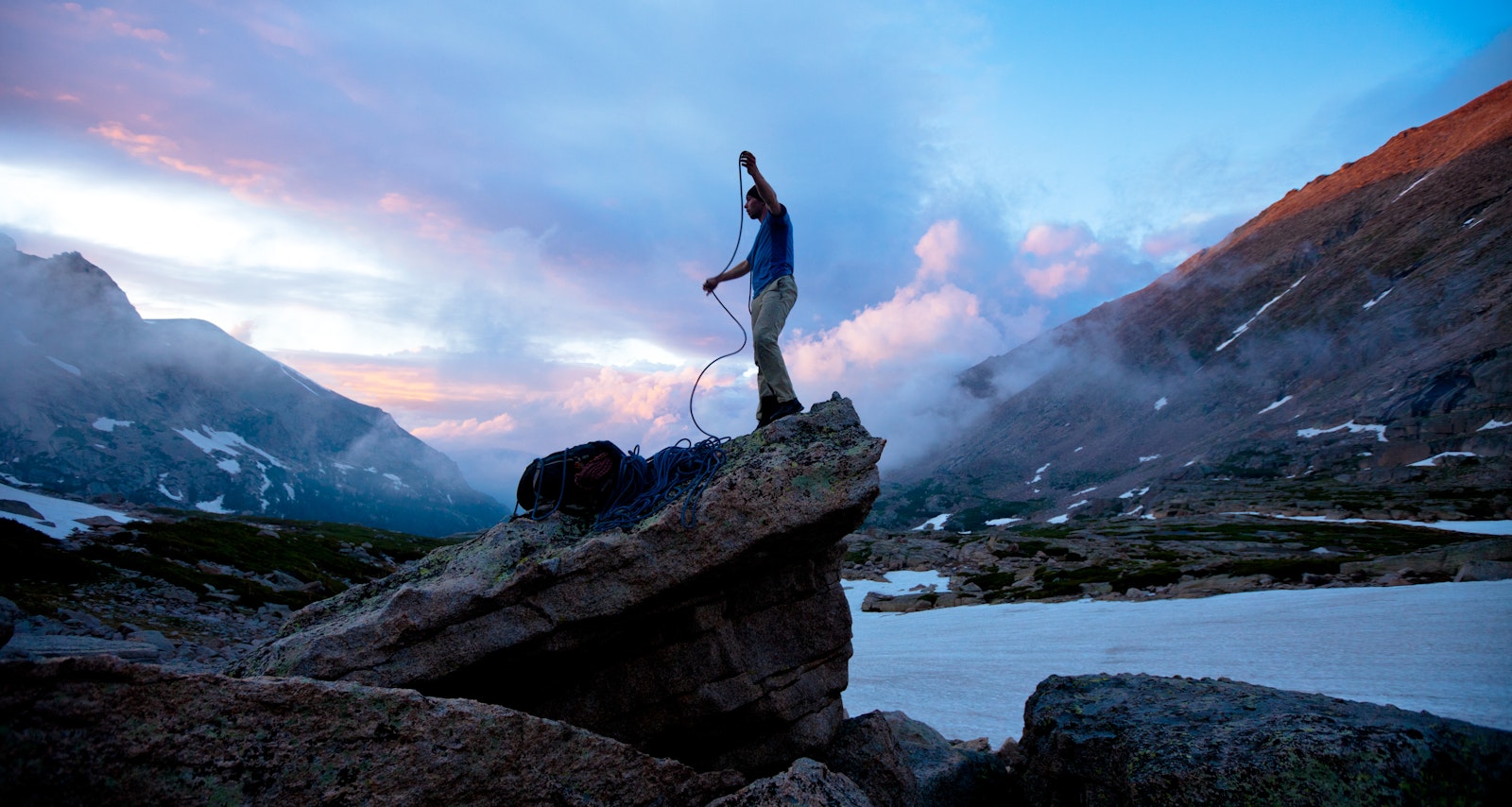 Rock climber at sunset coiling rope in Rocky Mountain National Park