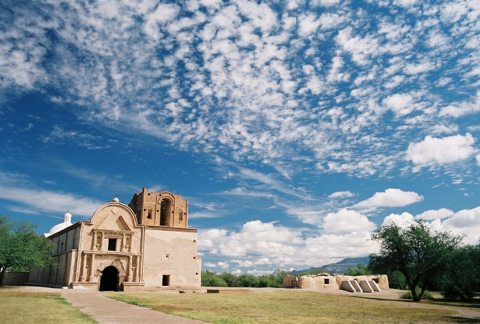 Exterior of mission-style church and Native American ruins