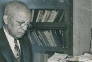 Historic photo of Carter G. Woodson writing at a desk