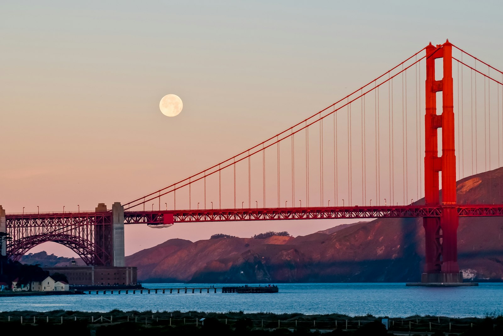 Golden Gate Bridge and the moon during the golden hour
