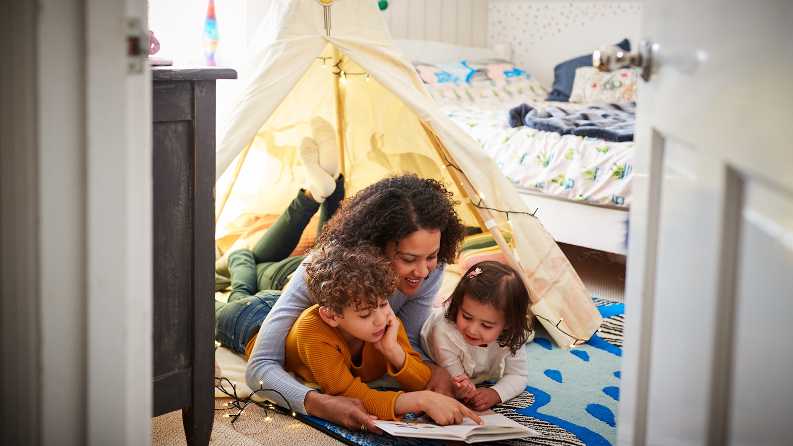 Family inside a tent, set up indoors.