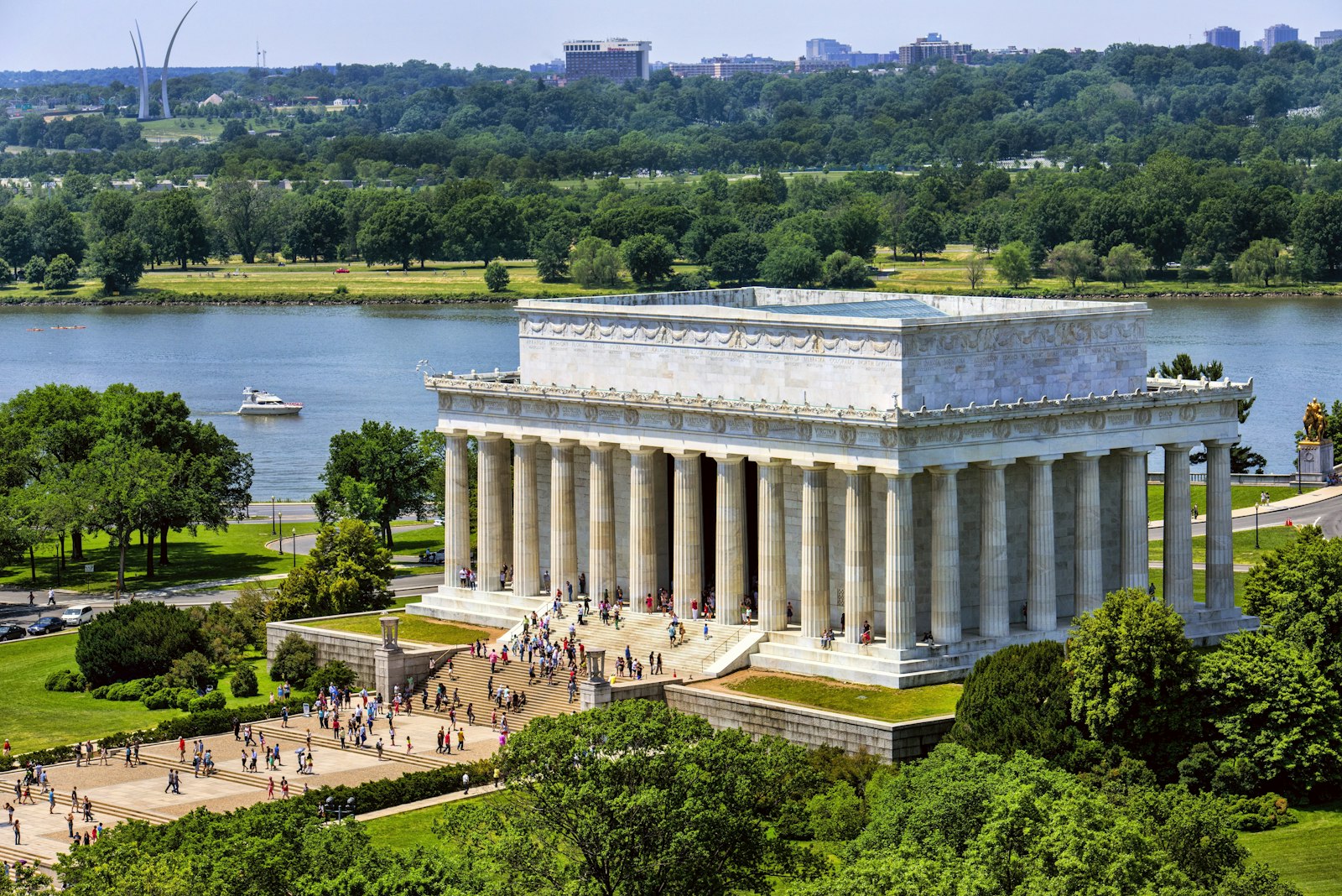 An aerial view of the marble Lincoln Memorial. Several visitors walk up its stairs