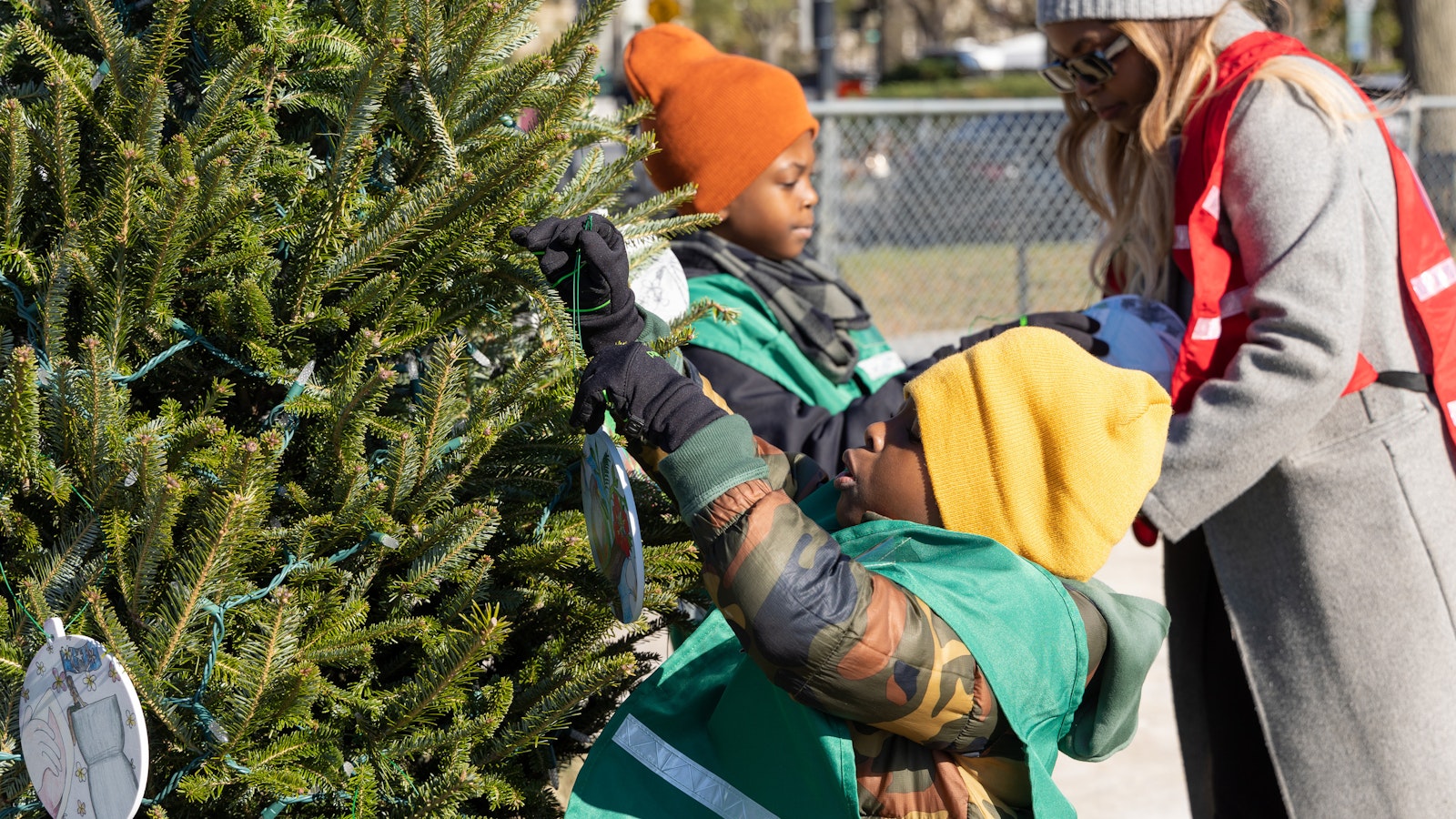 Volunteers decorate Christmas trees in front of the White House for the 2022 National Christmas Tree Lighting.