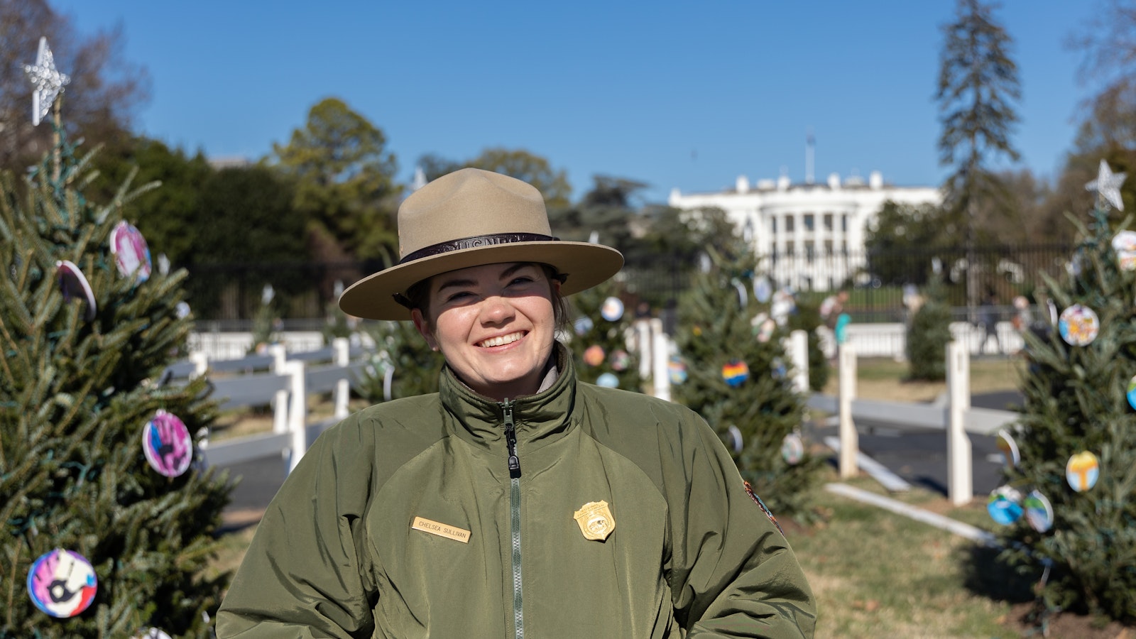A Park Ranger stands in front of the decorated Christmas trees for the 2022 National Christmas Tree Lighting.