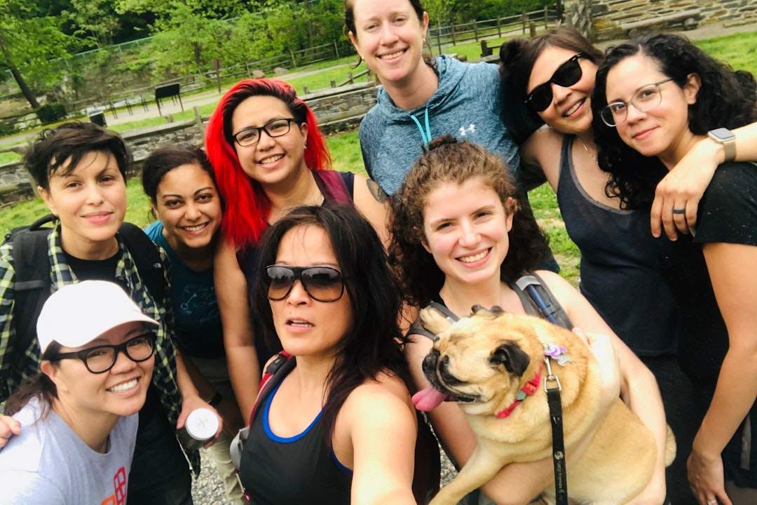 A group of people, and one pug, pose for a photo in Rock Creek Park