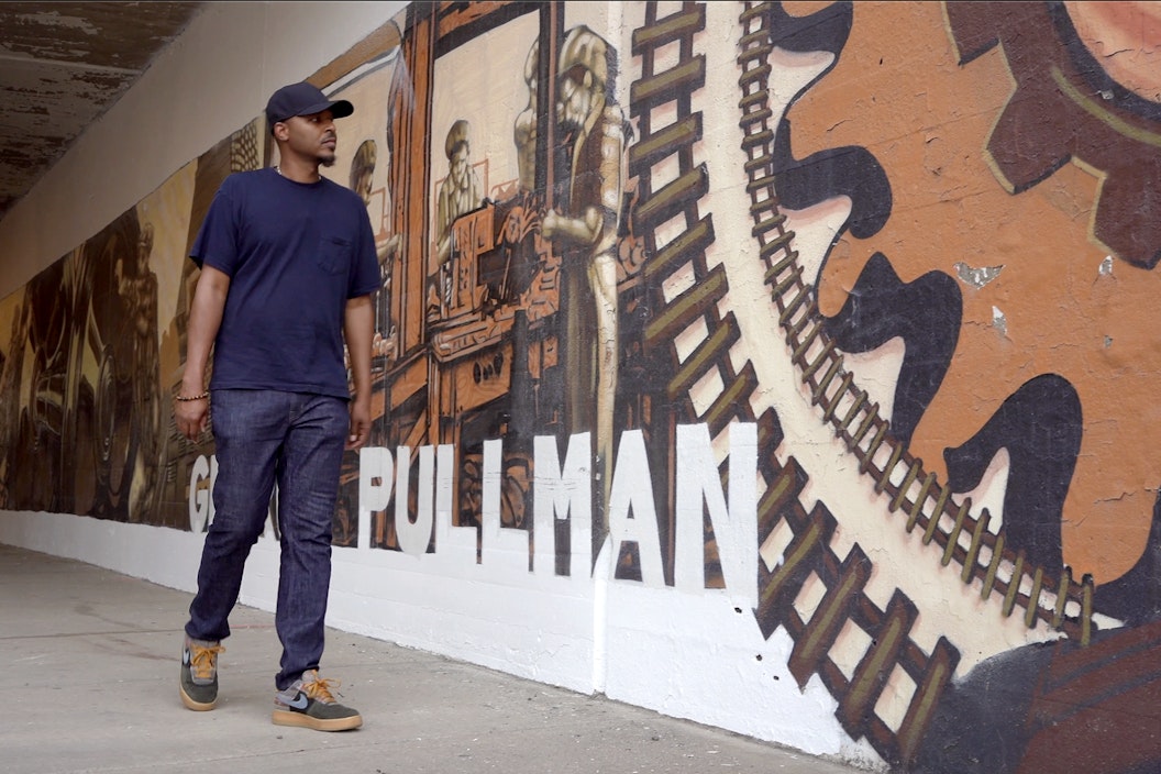 Joe Nelson walks along a mural depicting the history of Pullman